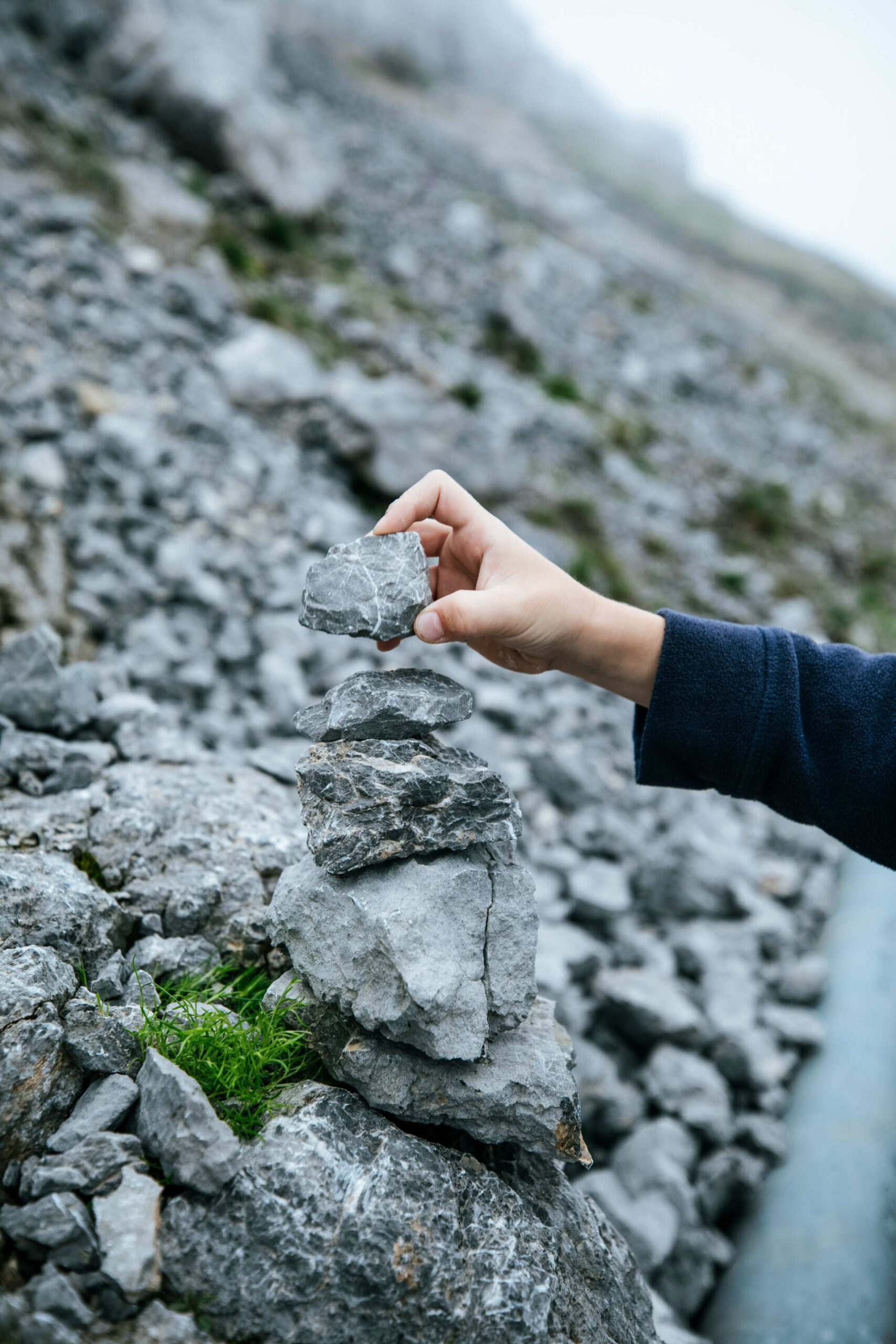 Eine Person baut einen kleinen Turm aus Steinen