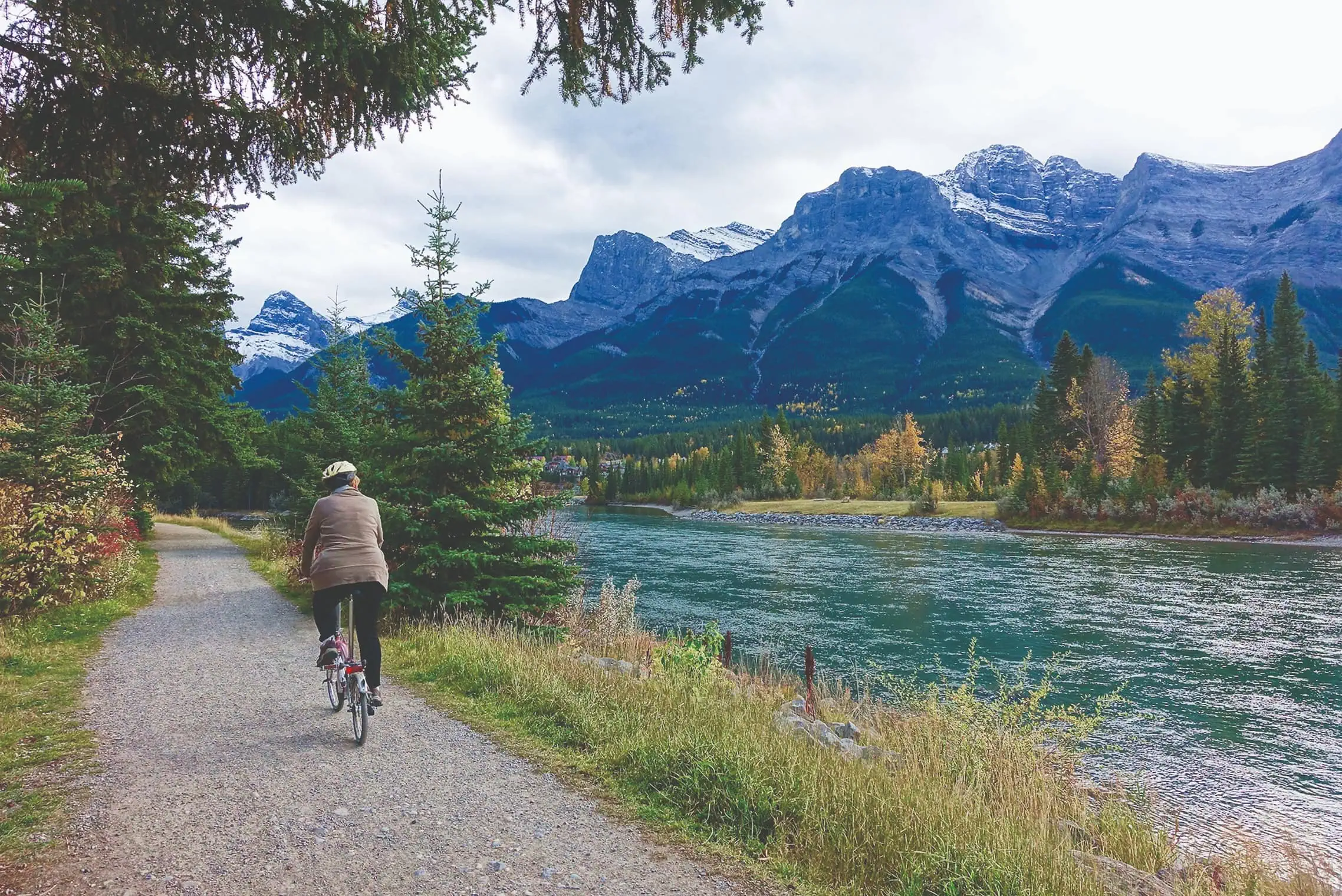 Landschaft mit Bergen und einem Radweg an einem Fluss